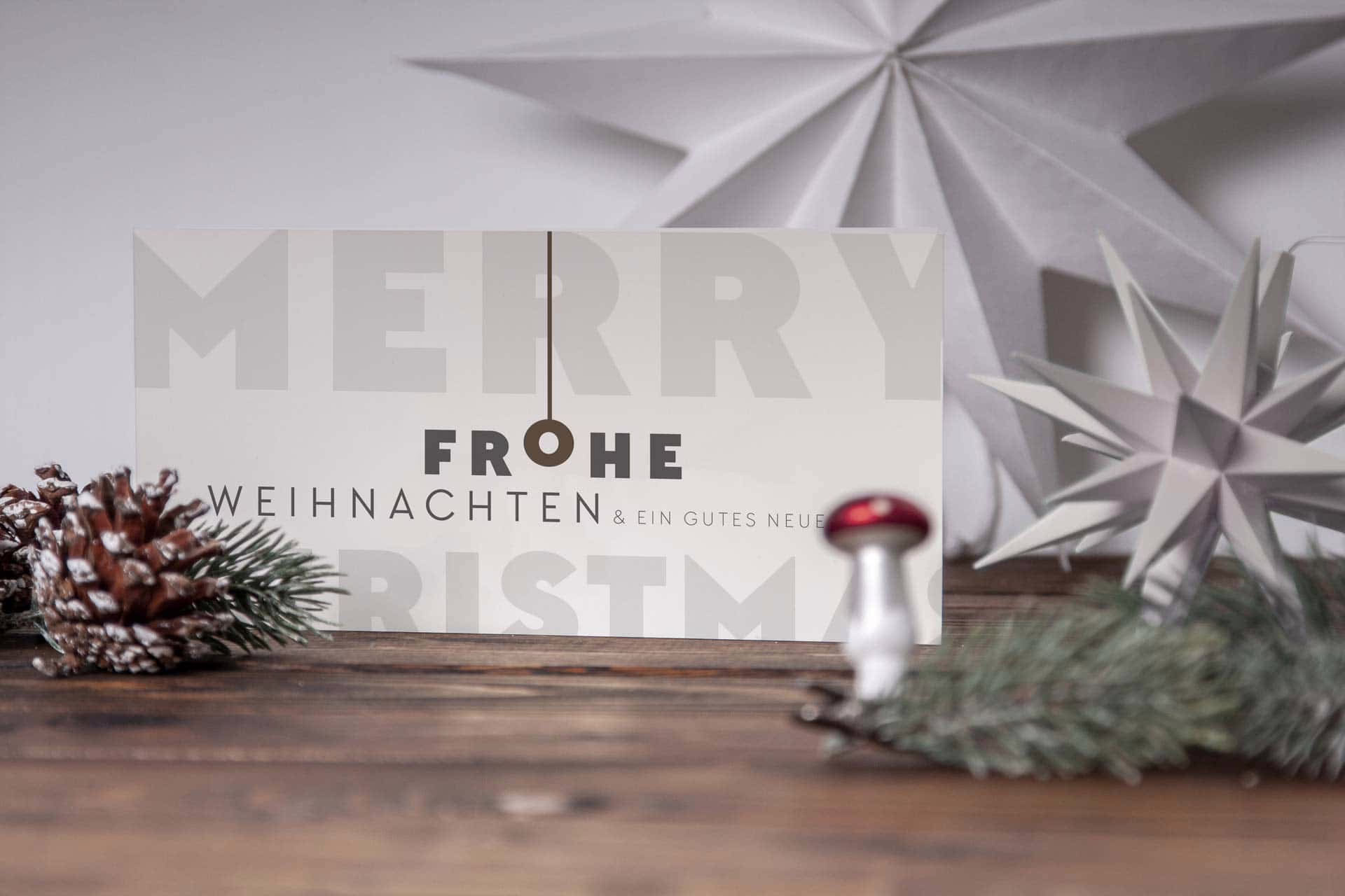 Typografische Weihnachtskarte in weihnachtlicher Deko.